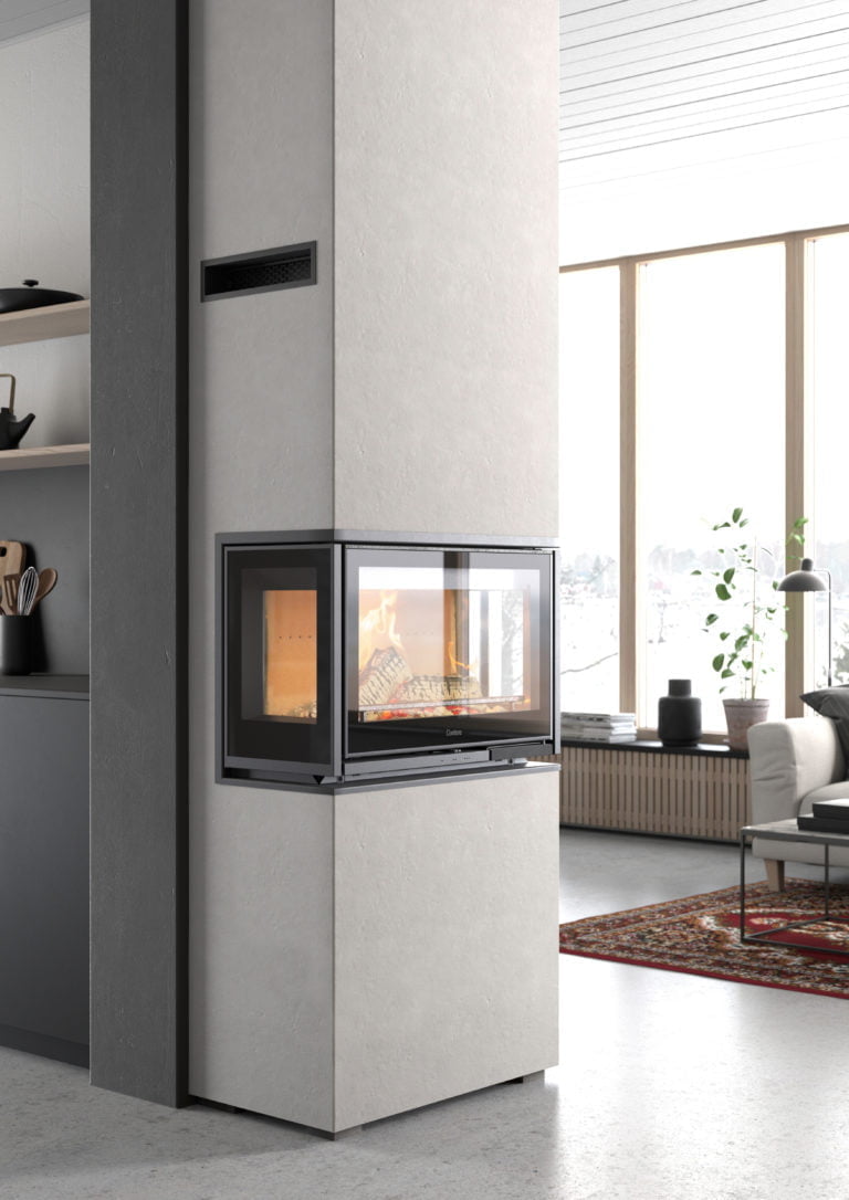 Modern eldstad i vardagsrum med stora fönster, ljusa väggar och inredning. Brasan brinner i en stilren kamin med glasfront.