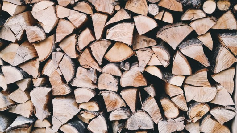 Staplad ved i olika storlekar med synliga årsringar. Perfekt för braskamin och uppvärmning.
