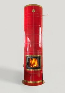 Röd kakelugn med brinnande eld, gulddetaljer, mot ljusgrå bakgrund. Perfekt för värme och inredning.