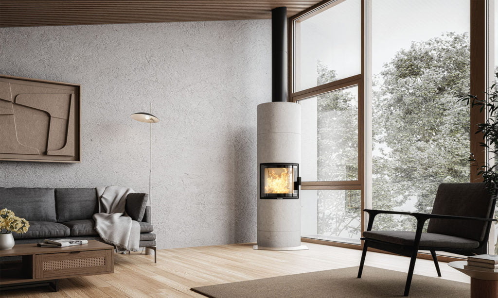 Modern vardagsrum med grå soffa, fåtölj och braskamin vid stora fönster. Väggkonst, golvlampa och trädetaljer skapar en stilren atmosfär.